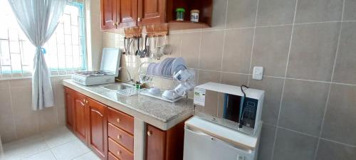 uma cozinha com um lavatório e um micro-ondas em Villas Karen em Tonsupa
