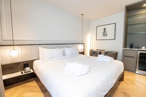 a bedroom with a large white bed with towels on it at Hôtel Boutique Ophelia in Quebec City