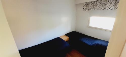 mały pokój z 2 łóżkami i oknem w obiekcie Huoneisto Pyy w mieście Suomussalmi