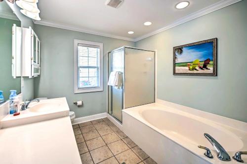 a bathroom with a tub and a sink at 1 Mi to Beach and Hot Tub Murrells Inlet Retreat! in Myrtle Beach
