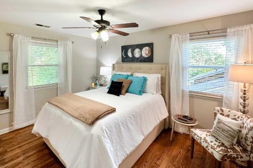 um quarto com uma cama branca e uma ventoinha de tecto em Recently Renovated Raleigh Retreat with Patio! em Raleigh
