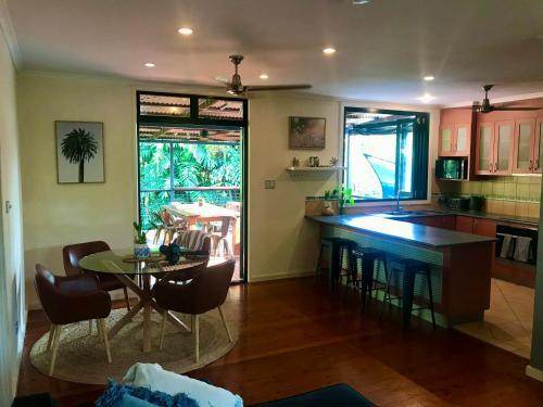 a kitchen with a table and a dining room at Elevated Tropical House in Casuarina