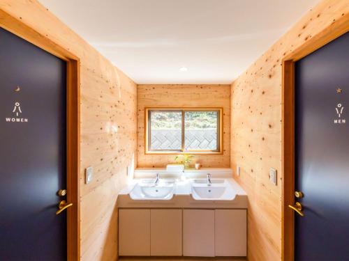 een badkamer met 2 wastafels en een raam bij Guest House Amami Long Beach 2 - Vacation STAY 64482v in Amami