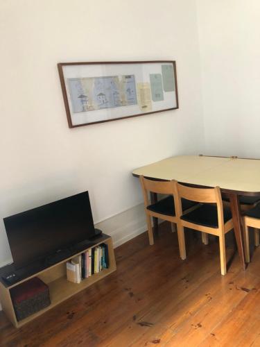 ein Esszimmer mit einem Tisch und einem Bücherregal in der Unterkunft cinco em 5 in Coimbra
