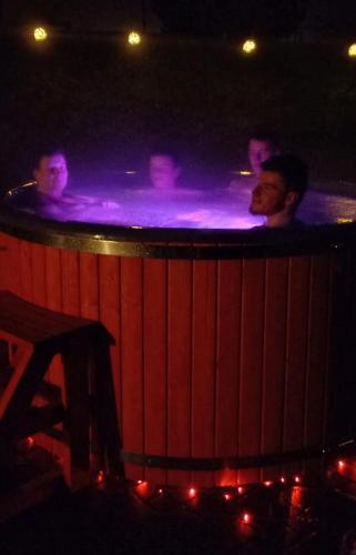a group of people in a hot tub at night at Viesu nams Vizbulītes in Talsi
