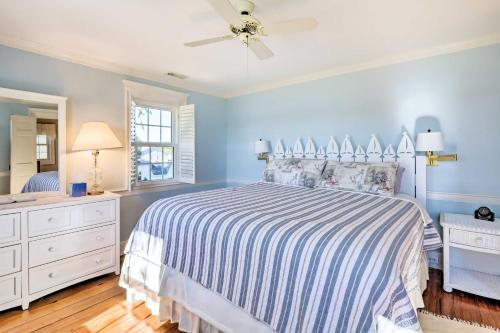 1 dormitorio azul con 1 cama y ventilador de techo en Pet-Friendly Quantico Home with River Views!, en Princess Anne
