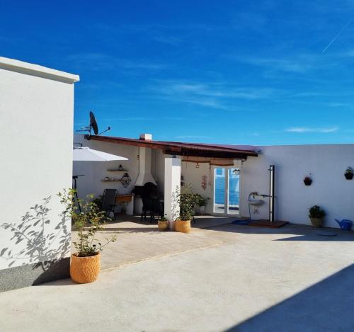 ein weißes Gebäude mit einer Terrasse mit Meerblick in der Unterkunft Beach house oasis Villa Livak in Kaštela