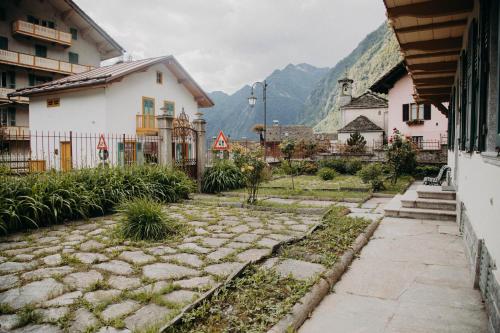 a cobblestone street in a town with houses and mountains at Residence Kalip&egrave; in Alagna Valsesia