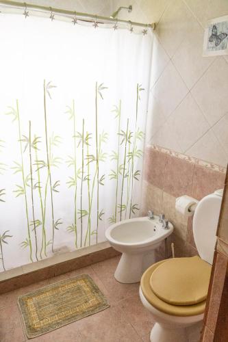 a bathroom with a toilet and a shower curtain with bamboo at Posada del Ñireco in San Carlos de Bariloche