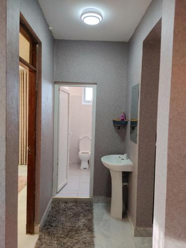 La salle de bains est pourvue de toilettes et d'un lavabo. dans l'établissement Ivory Homes, à Mombasa