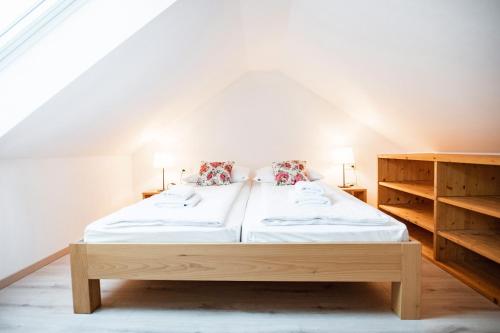una camera con letto in legno e 2 cuscini di Hiša 109 a Kranjska Gora