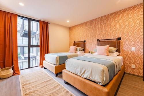 1 dormitorio con 2 camas y ventana grande en Modern apt w/balcony, pingpong table, roof top,gym, en Ciudad de México