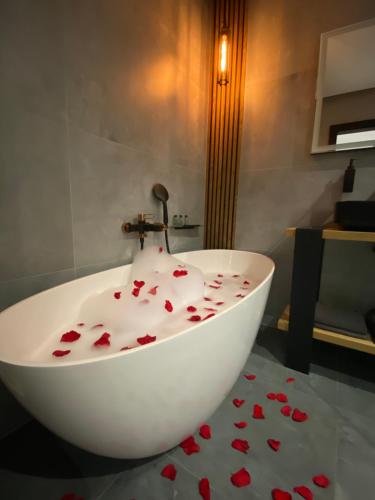 a bathroom with a white tub with red hearts on the floor at Apartament Grey Love w Czeladzi, FV, 8km do Katowic in Czeladź