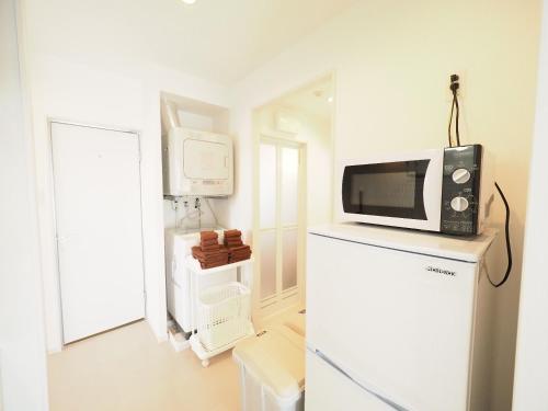 a microwave on top of a refrigerator in a kitchen at La Lumiere Oroku / Vacation STAY 1068 in Naha