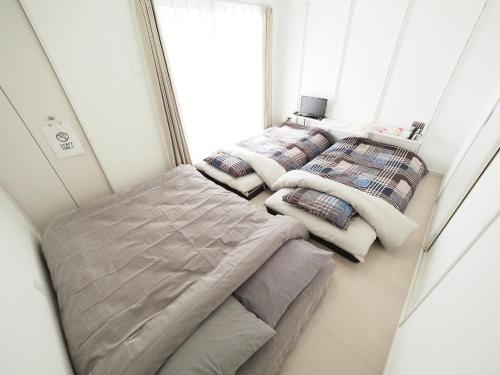 um quarto com 3 camas e uma janela em La Lumiere Oroku / Vacation STAY 1051 em Naha