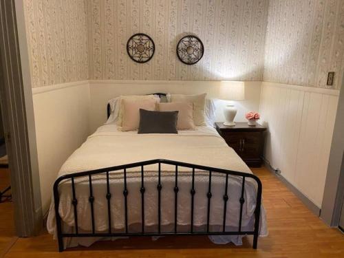 a bed in a bedroom with two clocks on the wall at Oui! Not Your Grandmother's Property in Knoxville