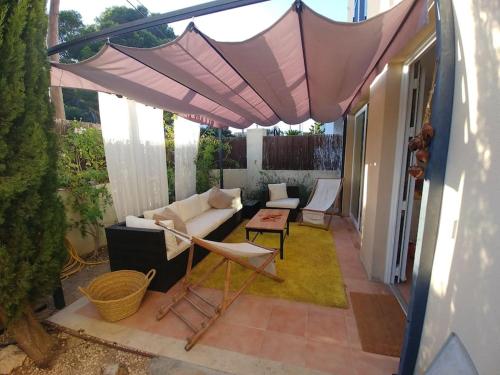 a patio with a couch and a table and an umbrella at El Rincón, peace at the sea, with jacuzzi in Cala Ratjada