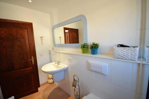 ein Bad mit einem Waschbecken und einem Spiegel in der Unterkunft El Rincón, peace at the sea, with jacuzzi in Cala Ratjada