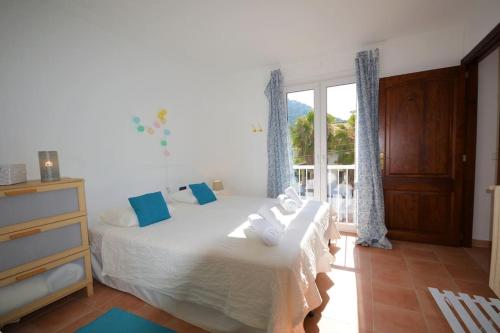 1 dormitorio con 2 camas con almohadas azules y ventana en El Rincón, peace at the sea, with jacuzzi en Cala Ratjada