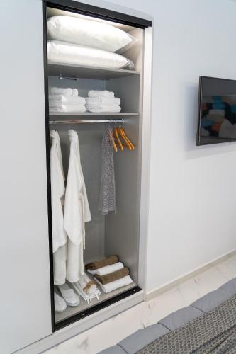 a walk in closet with white clothes and towels at The Lop Athens Holidays Luxury Suites in Athens