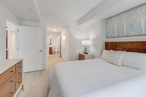 a white bedroom with a large bed and a kitchen at Global Luxury Suites at Capitol Hill in Washington, D.C.