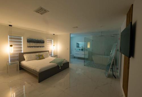 um quarto com uma cama e uma casa de banho com uma banheira em Miami Family Home 5BR Heated Pool & Jacuzzi L45 em Tamiami