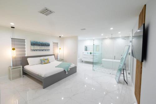 um quarto com uma cama e uma casa de banho com uma banheira em Miami Family Home 5BR Heated Pool & Jacuzzi L45 em Tamiami