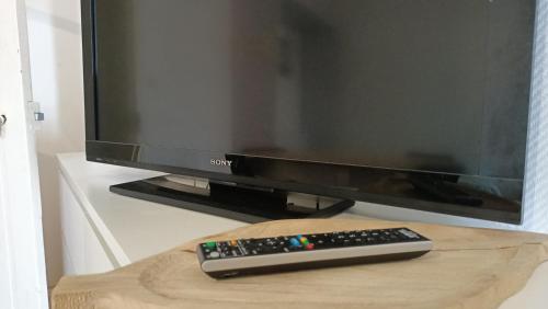 a computer monitor and a remote control sitting on a table at SW Cosy Apart - Chambly Persan Roissy in Persan