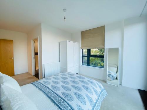 Habitación blanca con cama y ventana en Spacious two Bedroom Apartment in Balham, en Londres