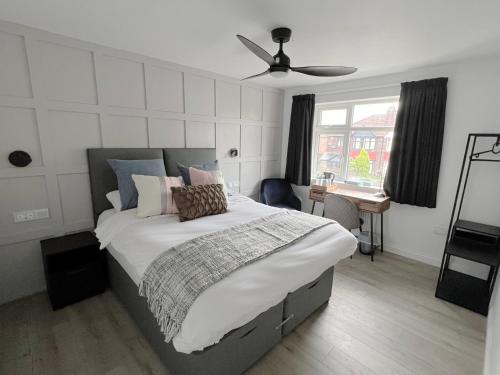 a bedroom with a large bed with a ceiling fan at United Home B&B in Manchester