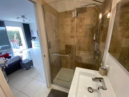 ein Bad mit einer Dusche und einem Waschbecken in der Unterkunft Les Lones avec jardin in Six-Fours-les-Plages