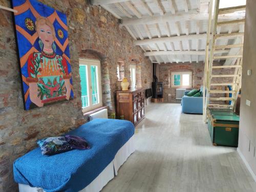 ein Schlafzimmer mit einem blauen Bett in einer Ziegelwand in der Unterkunft Inside the Wall in Lucca