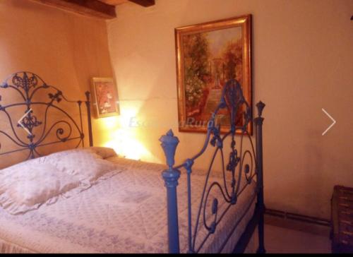 1 dormitorio con 1 cama y una foto en la pared en Casa Rural Abuela Simona, en Vega de Santa María
