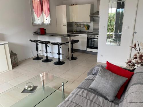 un salon avec un canapé et une table en verre dans l'établissement Les Lones avec jardin, à Six-Fours-les-Plages