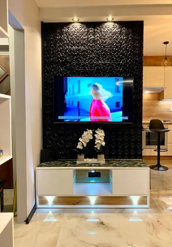 a living room with a tv on a wall at Studio Modlin in Nowy Dwór Mazowiecki