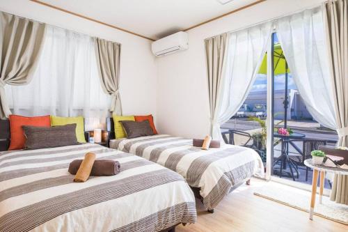 two beds in a room with a balcony at Laulea in Yaka