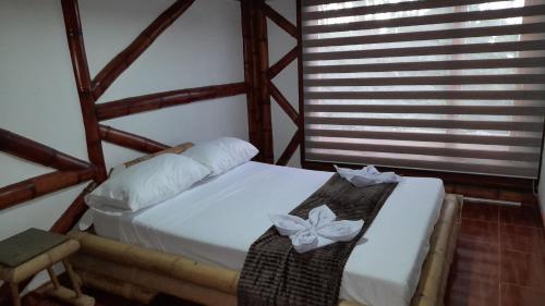 sypialnia z białym łóżkiem z łukami w obiekcie Apto/cabaña naranja w mieście Ulloa
