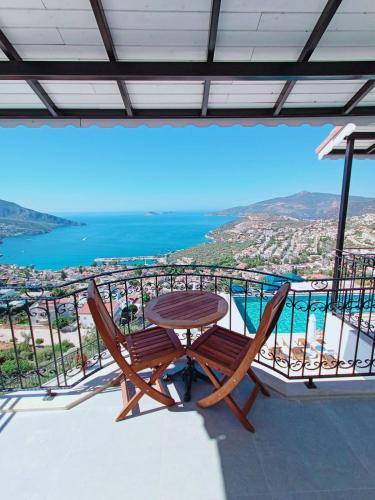 a table and chairs on a balcony with a view of the ocean at The Mediteran Hotel in Kalkan