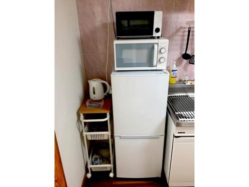a microwave on top of a refrigerator in a kitchen at Hotel Sunset Zanpa - Vacation STAY 50194v in Tokeshi