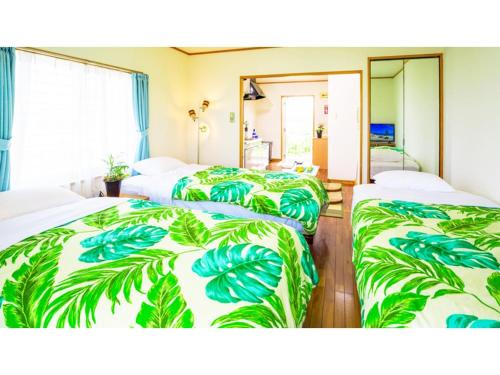 a hotel room with three beds with green leaves at Hotel Sunset Zanpa - Vacation STAY 50194v in Tokeshi