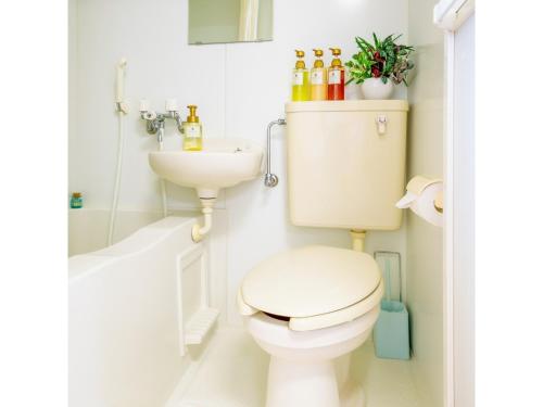 a white bathroom with a toilet and a sink at Hotel Sunset Zanpa - Vacation STAY 50194v in Tokeshi