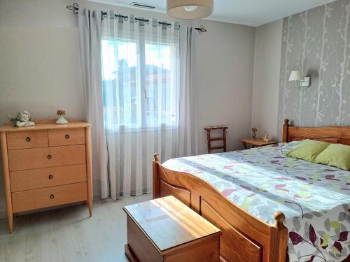um quarto com uma cama, uma cómoda e uma janela em Belle villa avec piscine vue montagne à 10 mn de la mer à Argeles em Argelès-sur-Mer