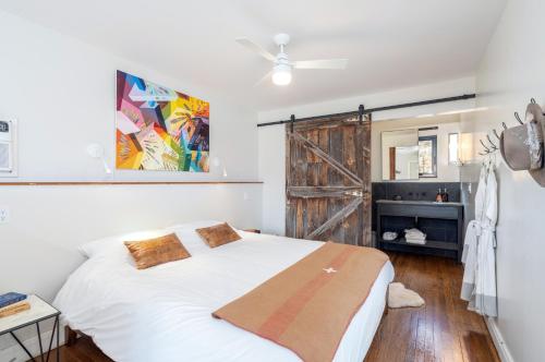 - une chambre avec un lit blanc et une porte coulissante dans l'établissement CampV, à Naturita