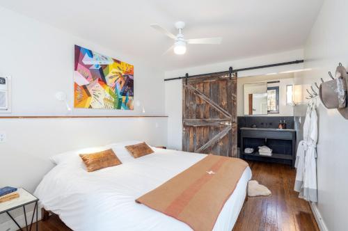 1 dormitorio con cama blanca y puerta corredera de granero en CampV, en Naturita