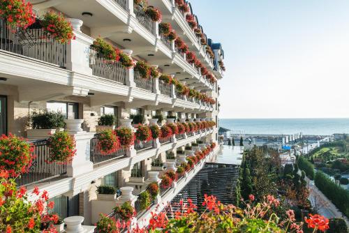 a building with potted plants on the side of it at Casa di Fiore SPA and Medical Hotel, Mineral Pools & Private Beach in Kranevo