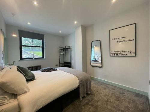 a bedroom with a large bed and a mirror at Cute 1-Bedroom Ground Apartment in Stoke Newington in London