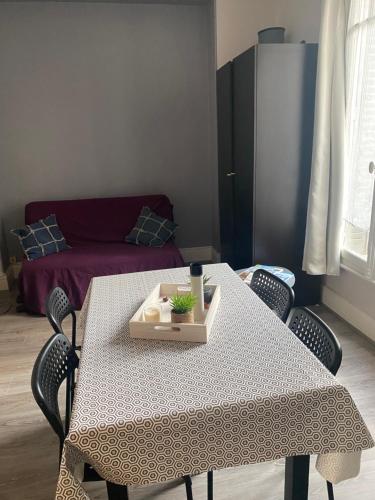 Studio cosy proche parcs, opéra, centre ville في فيشي: طاولة بيضاء مع كراسي وأريكة في غرفة المعيشة