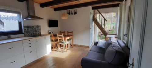 a living room with a couch and a kitchen and a table at Lavendowo in Piechowice