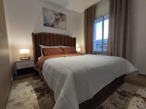 1 dormitorio con 1 cama grande y ventana en DLX01 - Appartement Deluxe bien équipé- Centre Ville Oujda en Oujda