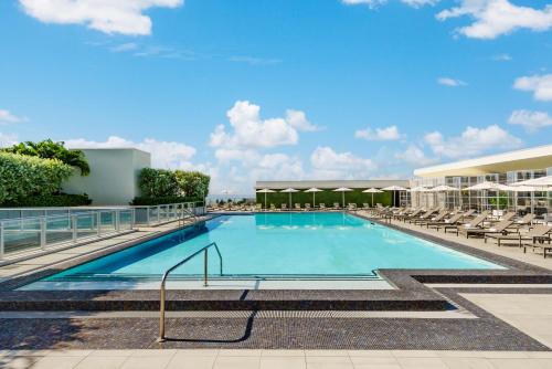 uma piscina com espreguiçadeiras e um edifício em Costa Hollywood Beach Resort - An All Suite Hotel em Hollywood